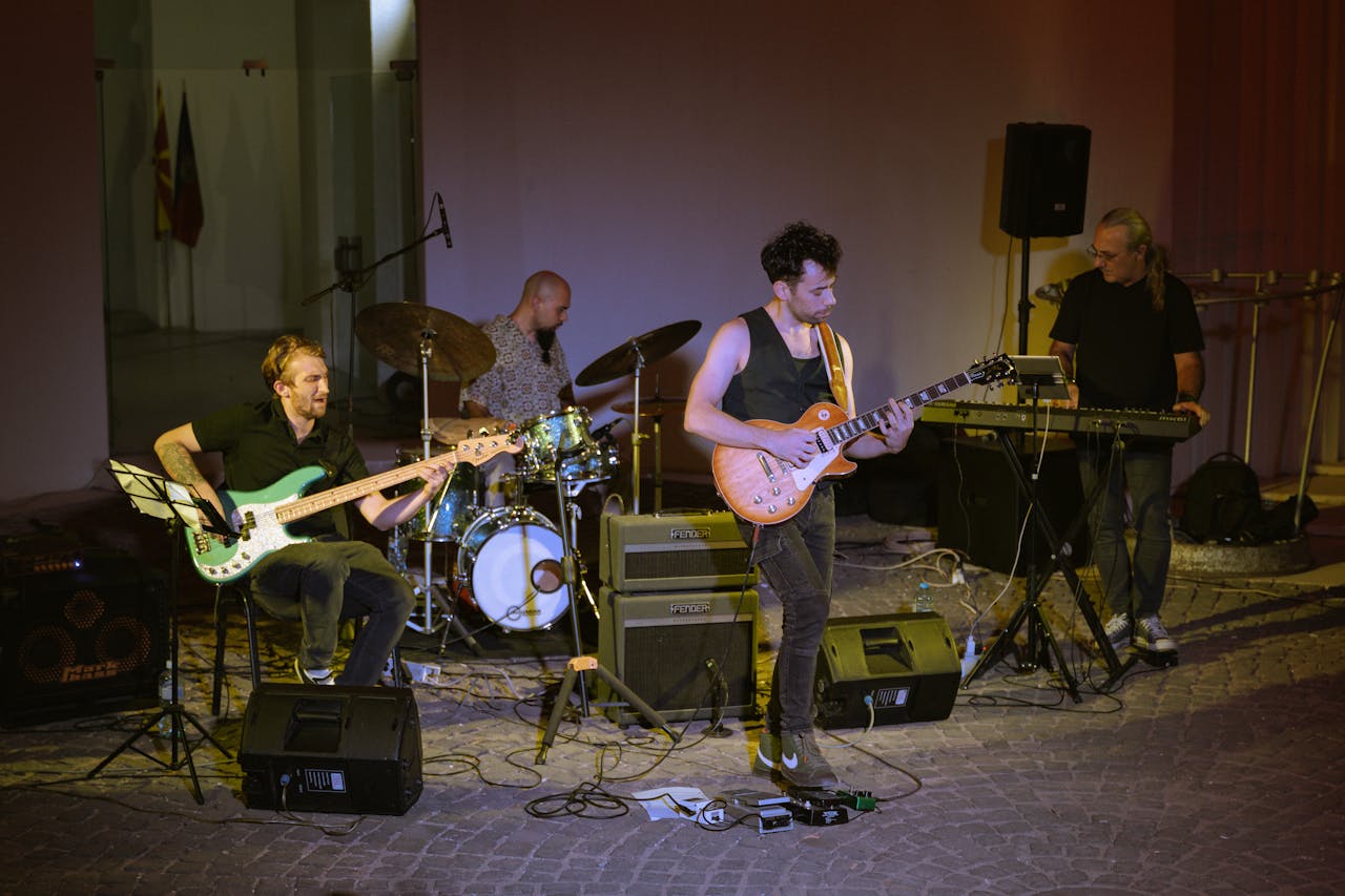 A band performing live music on stage with guitar, bass, and drums.